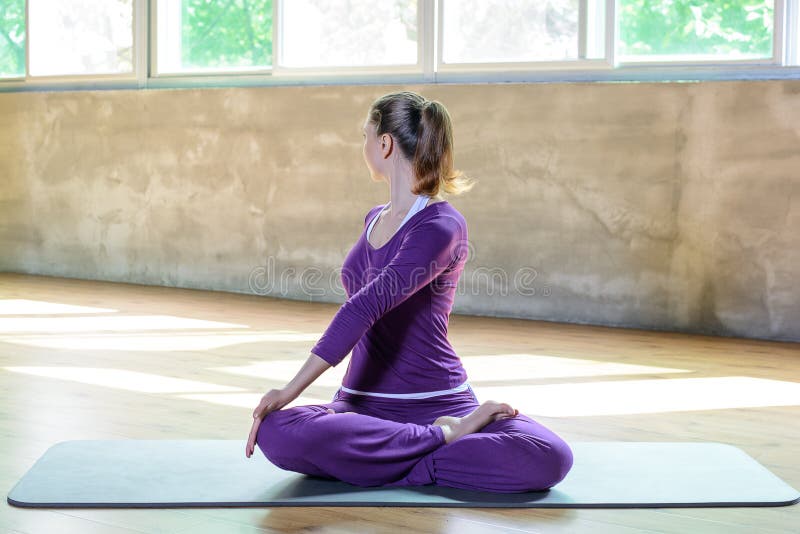 Den härliga idrotts- unga flickan gör yogaövning inomhus, wellnesspilates kopplar av tid arkivfoton Den härliga idrotts- unga flickan gör yogaövning inomhus, wellnesspilates kopplar av tid arkivfoton