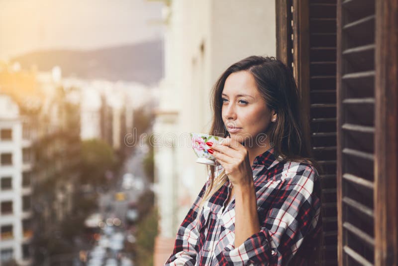 Close up of a woman holding in hands cup of coffee. Early morning routine. Sun light flair effect. Close up of a woman holding in hands cup of coffee. Early morning routine. Sun light flair effect