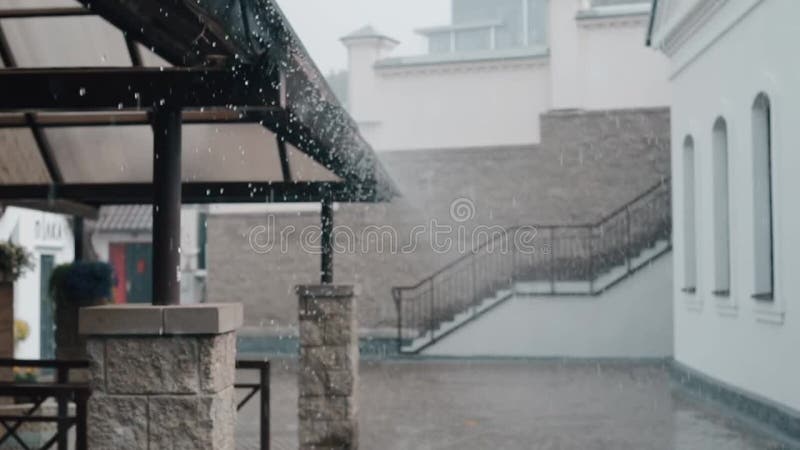 Den härliga sikten av regn tappar att falla ner från himlen och taket av en byggnad Suddig arkitektur, trappa