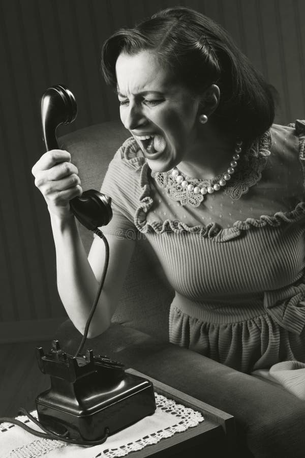 Angry woman screaming at retro phone, 1950 style. Angry woman screaming at retro phone, 1950 style