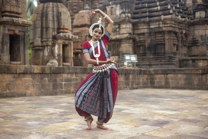 Den indiska klassiska odissidansaren bär den traditionella dräkten och att posera framme av den Mukteshvara templet, Bhubaneswar, arkivbild Den indiska klassiska odissidansaren bär den traditionella dräkten och att posera framme av den Mukteshvara templet, Bhubaneswar, arkivbild
