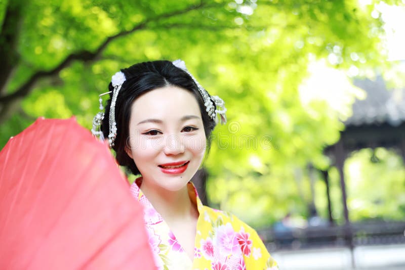 Den japanska kvinnan med kimonot i en vår parkerar japanskt le för brud arkivfoto Den japanska kvinnan med kimonot i en vår parkerar japanskt le för brud arkivfoto