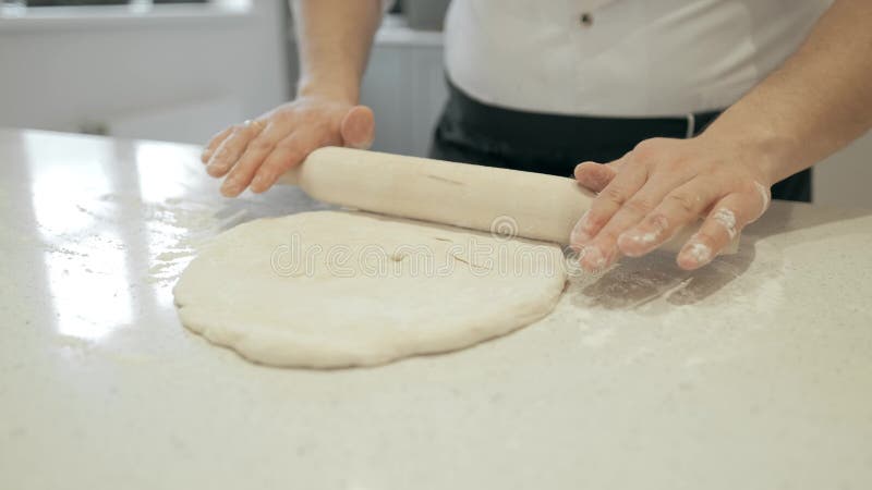 Den kalla kocken rullar ut degen på den funktionsdugliga yttersidan Laga mat pizzagrunden 4K