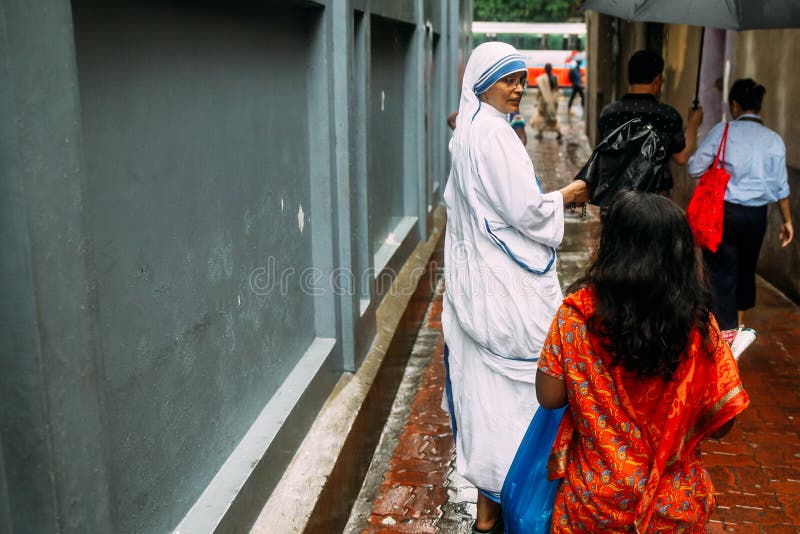 Den katolska systern talar med barn framme av huset av Mother Teresa i Kolkata, Indien