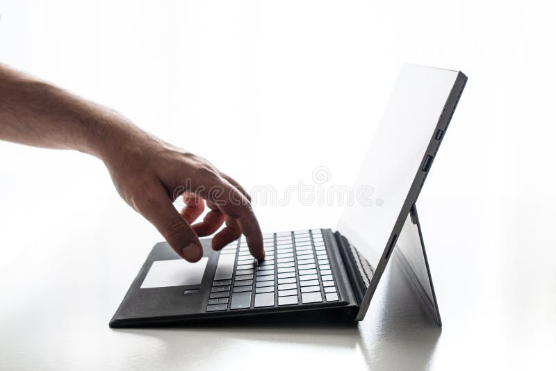 Den kompakta bärbara datorn exponerade den rena vita bakgrundshanden för tangenter, och fingrar fingrar att skjuta på tangent arkivfoto Den kompakta bärbara datorn exponerade den rena vita bakgrundshanden för tangenter, och fingrar fingrar att skjuta på tangent arkivfoto