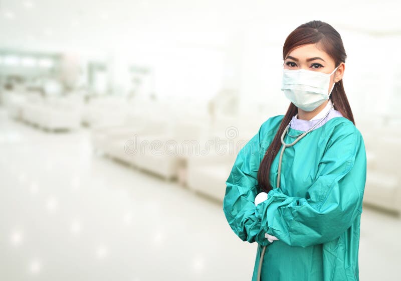 Den kvinnliga doktorn som bär en gräsplan, skurar och stetoskopet i sjukhus arkivbild Den kvinnliga doktorn som bär en gräsplan, skurar och stetoskopet i sjukhus arkivbild