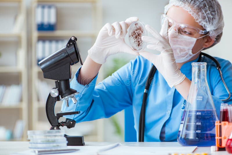 Den kvinnliga forskareforskaren som gör experiment i laboratorium royaltyfri bild Den kvinnliga forskareforskaren som gör experiment i laboratorium royaltyfri bild