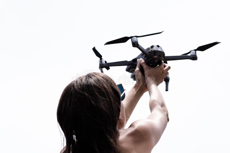 Den kvinnliga handen lanserar surret för flyget, som du kan ta med foto och videofilmande, närbilden arkivbild Den kvinnliga handen lanserar surret för flyget, som du kan ta med foto och videofilmande, närbilden arkivbild