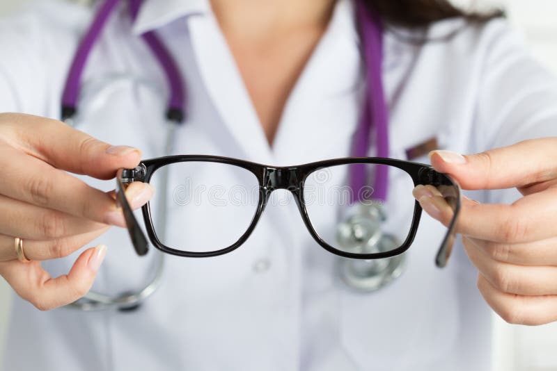 Den kvinnliga ögonläkaredoktorn räcker att ge par av exponeringsglas Bra vision arkivbild Den kvinnliga ögonläkaredoktorn räcker att ge par av exponeringsglas Bra vision arkivbild