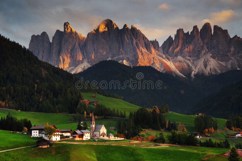 Den kyrkliga Santa Maddalena med den mäktiga Odle berggruppen i bakgrunden, på solnedgången arkivfoto