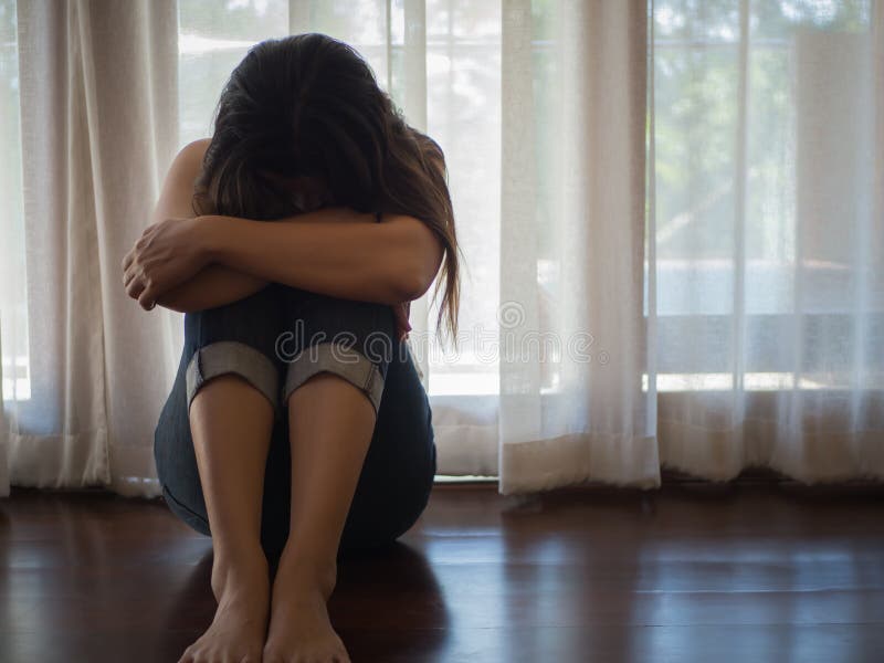 Den ledsna och misströstade kvinnan kramar hennes knä och gråter, medan sitta bara fotografering för bildbyråer Den ledsna och misströstade kvinnan kramar hennes knä och gråter, medan sitta bara fotografering för bildbyråer
