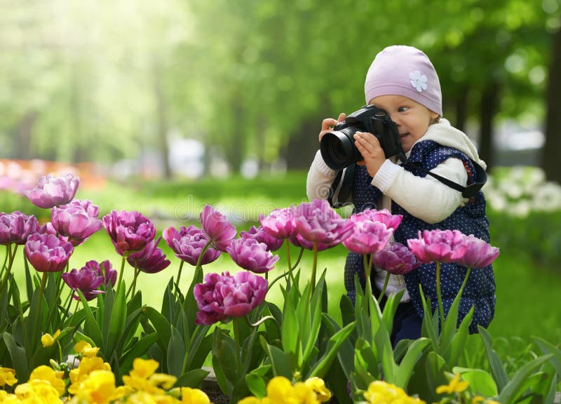 Den lilla amatörmässiga fotografen är lycklig och förvånad vid kvaliteten att ta bilden med hjälpen av den yrkesmässiga kameran royaltyfria foton
