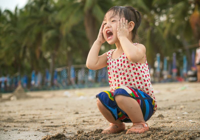 Den lilla asiatet behandla som ett barn flickan som spelar sand på stranden arkivbilder Den lilla asiatet behandla som ett barn flickan som spelar sand på stranden arkivbilder