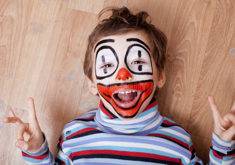 Den lilla gulliga pojken med facepaint som clown, pantomimic uttryck stänger sig upp arkivfoto Den lilla gulliga pojken med facepaint som clown, pantomimic uttryck stänger sig upp arkivfoto