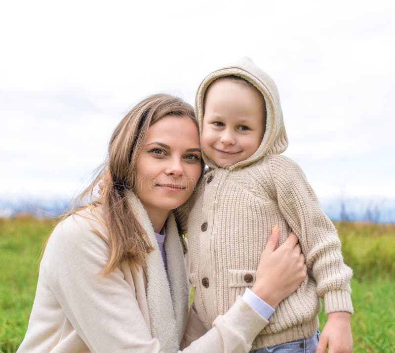 Den lilla pojken son hugger mamma glad leende, ömtåligt barn, höstdagars varma kläder, kvinna och mamma spelar barn arkivfoton Den lilla pojken son hugger mamma glad leende, ömtåligt barn, höstdagars varma kläder, kvinna och mamma spelar barn arkivfoton