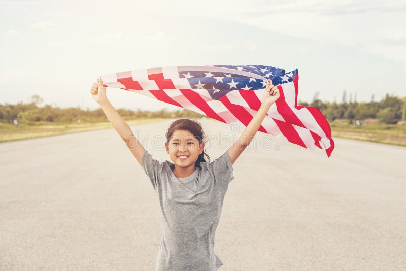 Den lyckliga asiatiska lilla flickan med amerikanska flaggan USA firar 4th Juli fotografering för bildbyråer Den lyckliga asiatiska lilla flickan med amerikanska flaggan USA firar 4th Juli fotografering för bildbyråer
