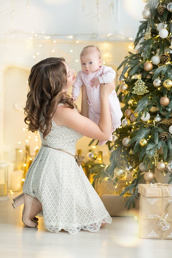 Den lyckliga det familjmodern och barnet behandla som ett barn pojken på julmorgon på trädet med gåvor, hem- garnering, inre hus royaltyfri fotografi Den lyckliga det familjmodern och barnet behandla som ett barn pojken på julmorgon på trädet med gåvor, hem- garnering, inre hus royaltyfri fotografi