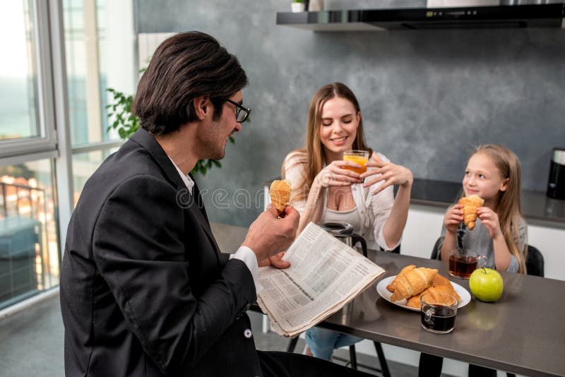 Den lyckliga familjen har en frukost hemma royaltyfri fotografi Den lyckliga familjen har en frukost hemma royaltyfri fotografi