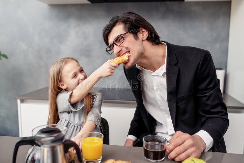 Den lyckliga familjen har en frukost hemma royaltyfri bild Den lyckliga familjen har en frukost hemma royaltyfri bild
