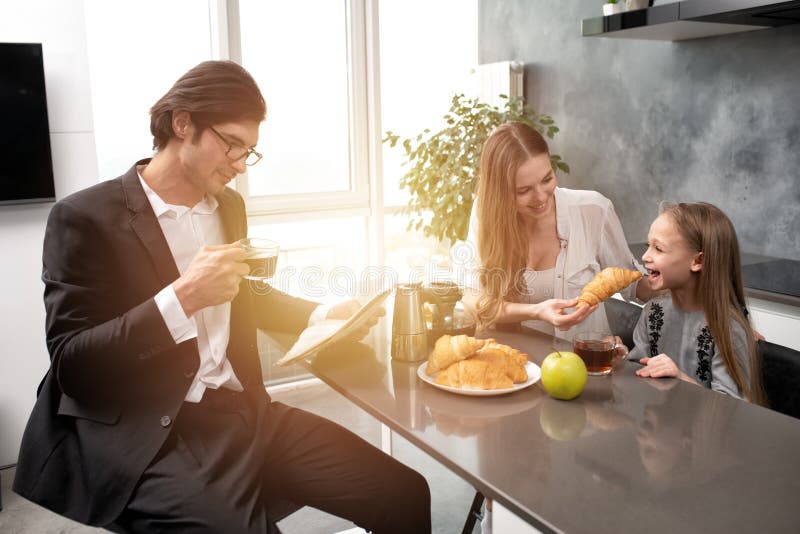Den lyckliga familjen har en frukost hemma royaltyfria bilder Den lyckliga familjen har en frukost hemma royaltyfria bilder