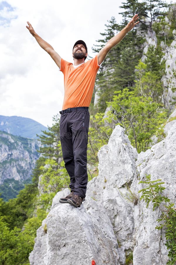Den lyckliga fotvandraremannen som firar på bergöverkanten med armar, up nolla royaltyfria bilder Den lyckliga fotvandraremannen som firar på bergöverkanten med armar, up nolla royaltyfria bilder