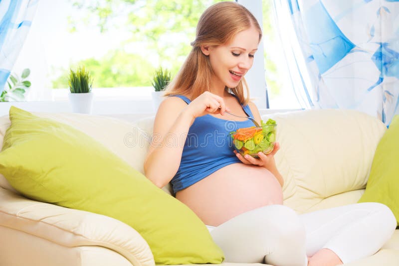 Den lyckliga gravida kvinnan äter sund matgrönsaksallad arkivbild Den lyckliga gravida kvinnan äter sund matgrönsaksallad arkivbild