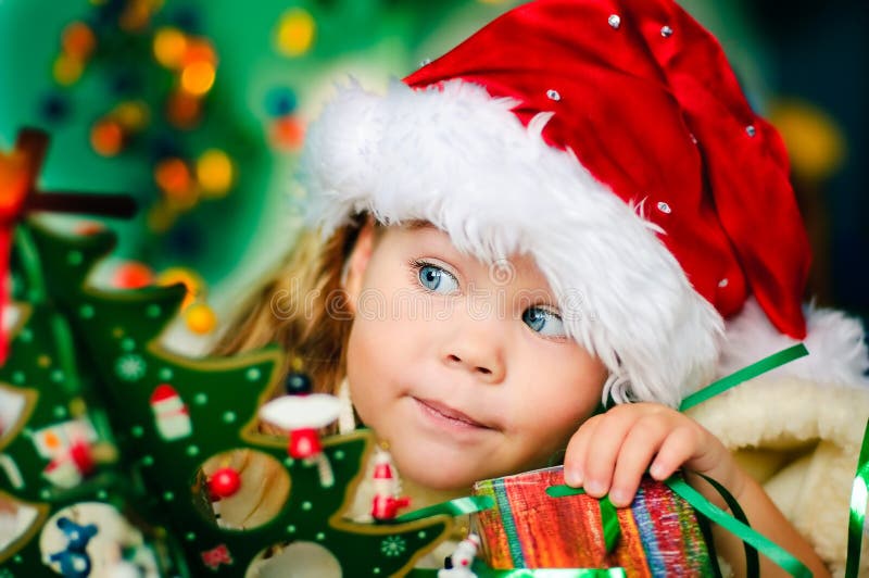 Den lyckliga julflickan har hatt s små santa arkivfoto