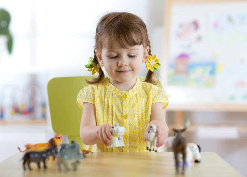 Den lyckliga lilla litet barnflickan spelar zoo hemma eller daycaremitten royaltyfria bilder Den lyckliga lilla litet barnflickan spelar zoo hemma eller daycaremitten royaltyfria bilder