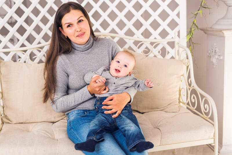 Den lyckliga modern med behandla som ett barn pojken i rummet royaltyfri bild Den lyckliga modern med behandla som ett barn pojken i rummet royaltyfri bild