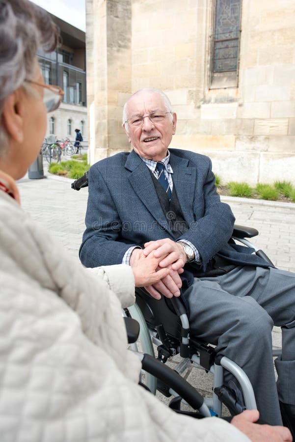 Den lyckliga pensionären handikapp par som rymmer händer arkivbild Den lyckliga pensionären handikapp par som rymmer händer arkivbild