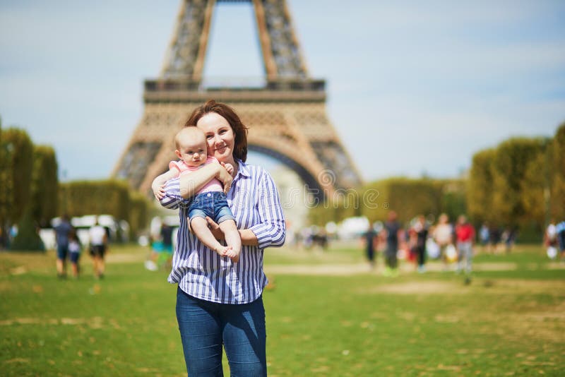 Den lyckliga unga kvinnan som rymmer hennes litet, behandla som ett barn flickan i Paris royaltyfri foto Den lyckliga unga kvinnan som rymmer hennes litet, behandla som ett barn flickan i Paris royaltyfri foto
