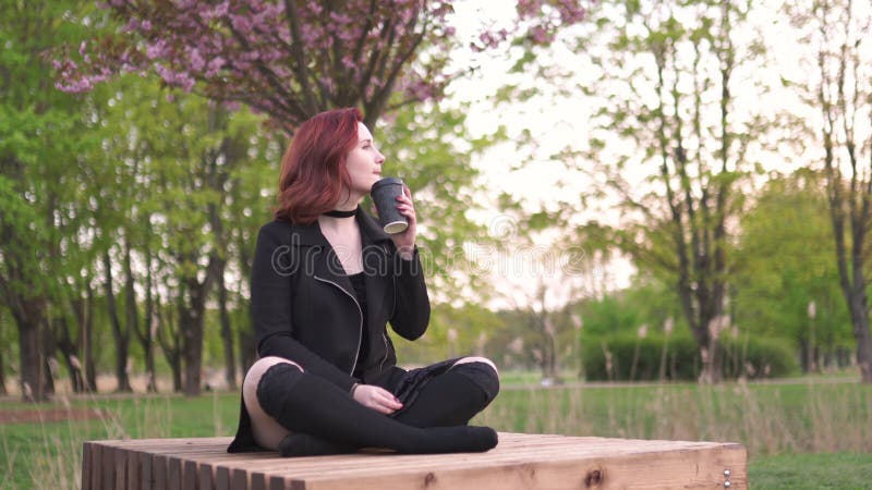 Den lyckliga unga loppdansarekvinnan som tycker om fri tid i en sakura k? rsb? rblomning, parkerar - den Caucasian vita r? dh? rig ma lager videofilmer