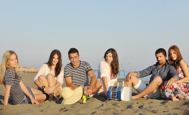 Den lyckliga ungdomaren grupp har gyckel på strand fotografering för bildbyråer Den lyckliga ungdomaren grupp har gyckel på strand fotografering för bildbyråer