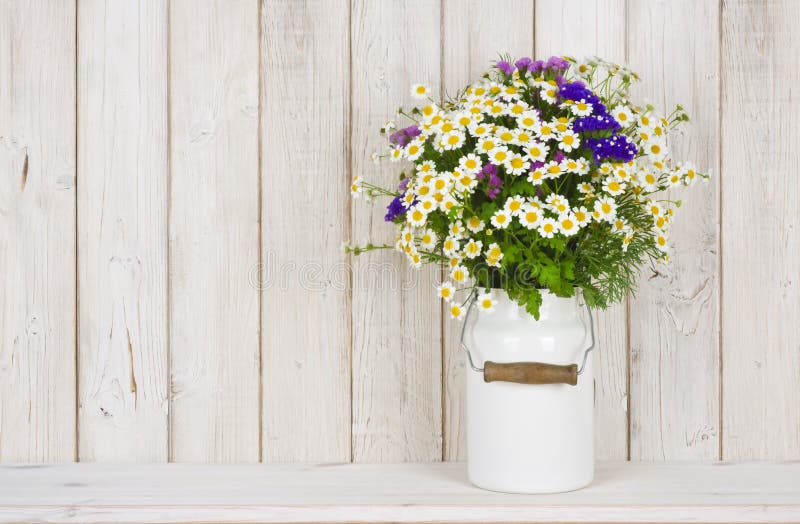 Den lösa kamomillen blommar buketten på tabellen över träplankabakgrund royaltyfri bild Den lösa kamomillen blommar buketten på tabellen över träplankabakgrund royaltyfri bild