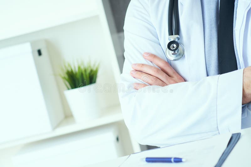 Den manliga medicinska doktorn som poserar med korsade armar, labblaget, stetoskopet och h?nder st?nger sig upp, sjukv?rdprofessi royaltyfri foto Den manliga medicinska doktorn som poserar med korsade armar, labblaget, stetoskopet och h?nder st?nger sig upp, sjukv?rdprofessi royaltyfri foto