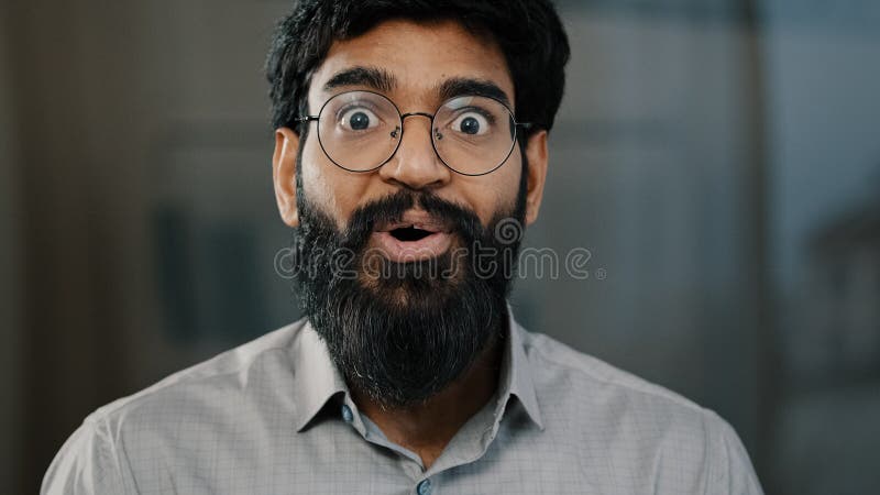 Den manliga porträttens överraskande känslosamhet som förvånade arabisk förvånad man i ögonglasen gör stora ögon indianska royaltyfria foton