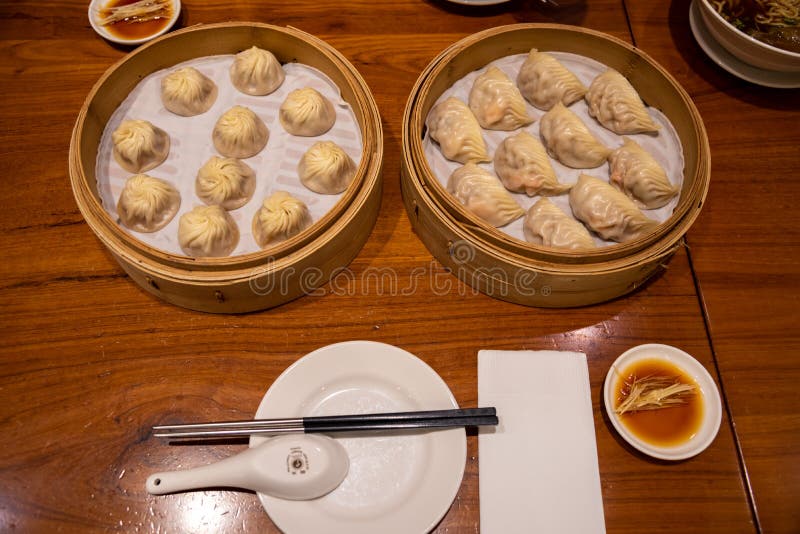 Chinese steamed steamed bun  baozi  named Xiaolongbao also called a soup dumpling. It is traditionally prepared in xiolong small bamboo steaming basket. Michelin star awarded Din Tai Fung restaurant. Chinese steamed steamed bun  baozi  named Xiaolongbao also called a soup dumpling. It is traditionally prepared in xiolong small bamboo steaming basket. Michelin star awarded Din Tai Fung restaurant