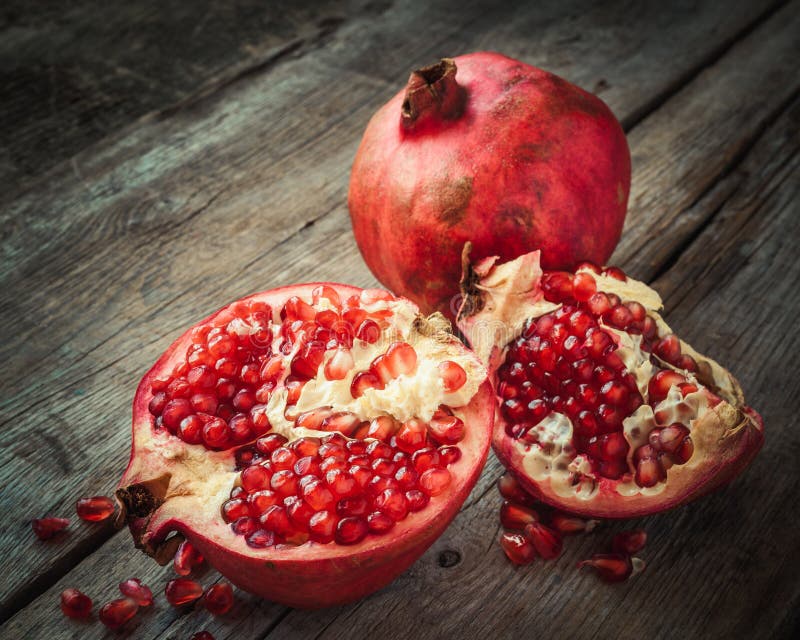 Den mogna granatäppleskivan och hel röd granatrött bär frukt på tabellen arkivbilder