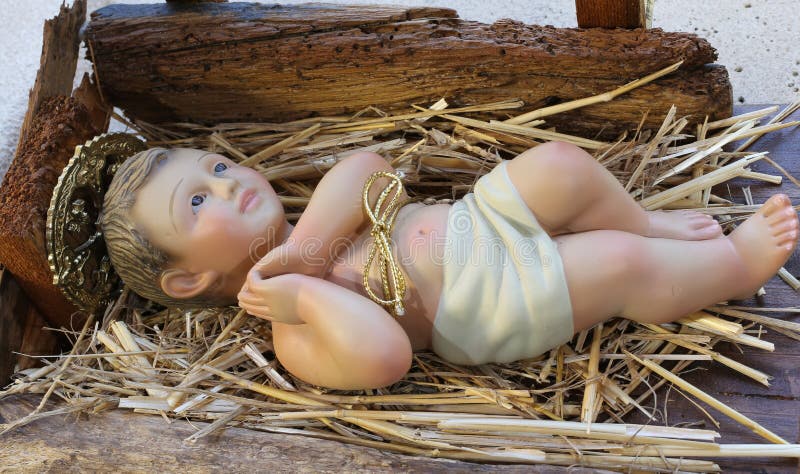 Den nyfödda forntida statyn av jesus behandla som ett barn att vila i krubban arkivbild Den nyfödda forntida statyn av jesus behandla som ett barn att vila i krubban arkivbild