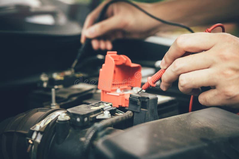 Den nära övre bilmekanikern använder bilbatterimetern för att mäta olika värden och för att analysera det royaltyfria foton