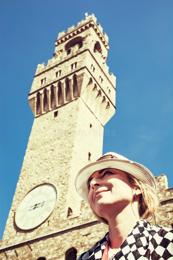 Den nätta kvinnan poserar under Palazzoen Vecchio i Florence royaltyfria bilder Den nätta kvinnan poserar under Palazzoen Vecchio i Florence royaltyfria bilder