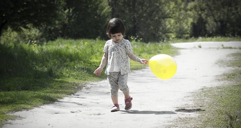 Den nätta lilla flickan går i parkera royaltyfria bilder