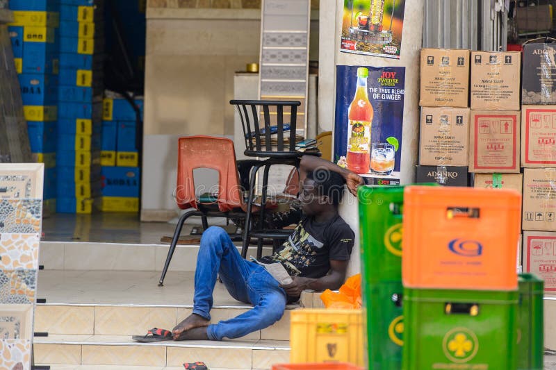 Den oidentifierade ghananska mannen sitter på trappa i lokal by royaltyfri fotografi