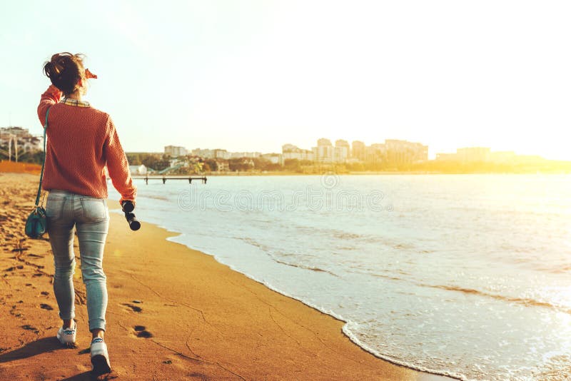 Den oigenkännliga fotvandrareflickan i jeans promenerar kusten med kikare, bakre sikt Spana Wanderlust Holidays Concept royaltyfri foto Den oigenkännliga fotvandrareflickan i jeans promenerar kusten med kikare, bakre sikt Spana Wanderlust Holidays Concept royaltyfri foto