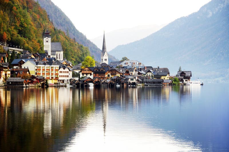 Den pittoreska byn av Hallstatt reflekteras i sjön i en solig höstdag arkivbild Den pittoreska byn av Hallstatt reflekteras i sjön i en solig höstdag arkivbild