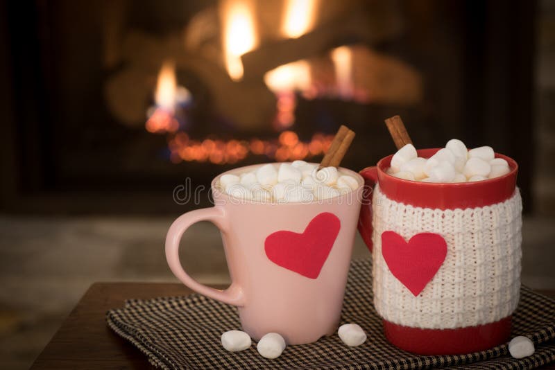 Den romantiska dagen för valentin` s varm spisplats med röd och rosa kakao rånar med röda hjärtor i hemtrevlig vardagsrum