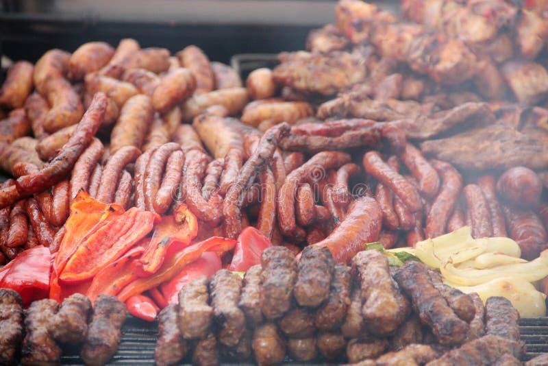 Den rumänska mixeda grillen med för griskött, fega och traditionella tunna korvar för nötkött som, säljs på en gatamat, stannar royaltyfria bilder Den rumänska mixeda grillen med för griskött, fega och traditionella tunna korvar för nötkött som, säljs på en gatamat, stannar royaltyfria bilder