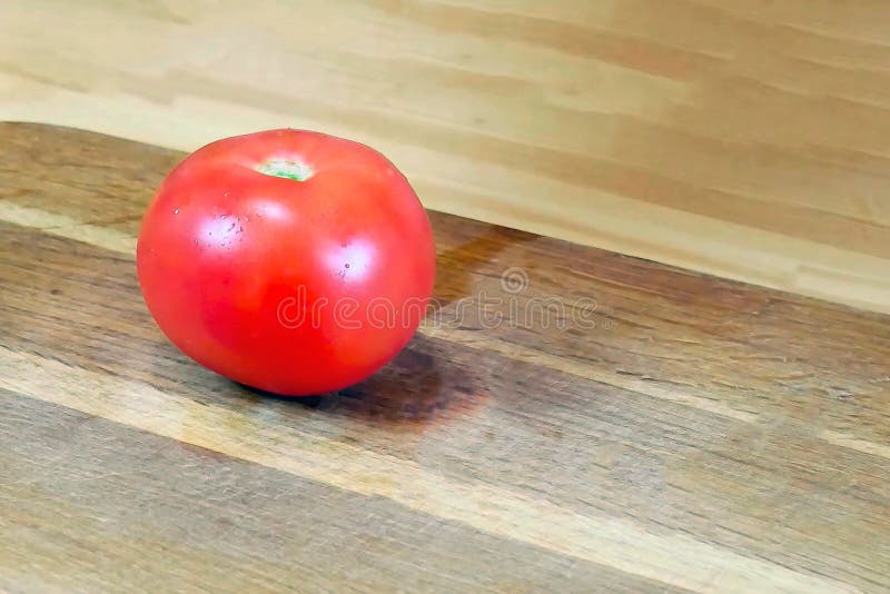 Den röda mogna sommartomaten ligger på träskivor royaltyfri foto