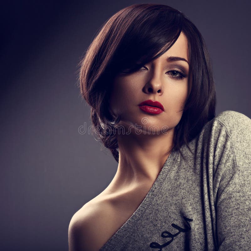 Den sexiga uttrycksfulla makeupkvinnan med kort guppar hårstil, röda kanter