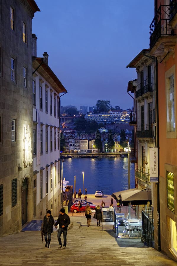 Den smala gatan som leder till kanten av Oporto Ribeira i aftonen royaltyfri bild Den smala gatan som leder till kanten av Oporto Ribeira i aftonen royaltyfri bild